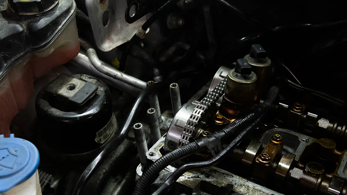 Détails d'un moteur automobile montrant des composants du système d'injection, des tuyaux et des éléments métalliques.