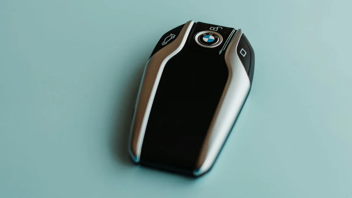Clé à puce automobile de marque BMW, avec un design moderne et des boutons pour le verrouillage et le déverrouillage.
